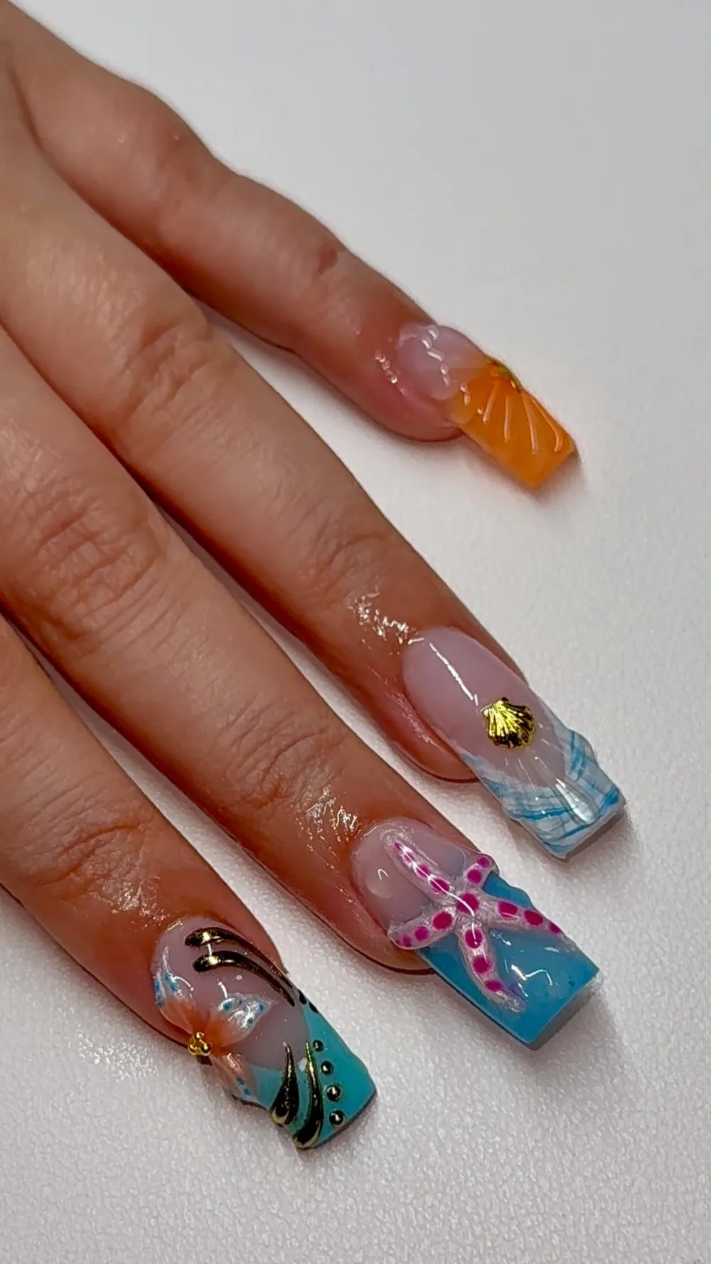 Long square nails with 3D starfish, seashell and flower details in blue, teal and orange